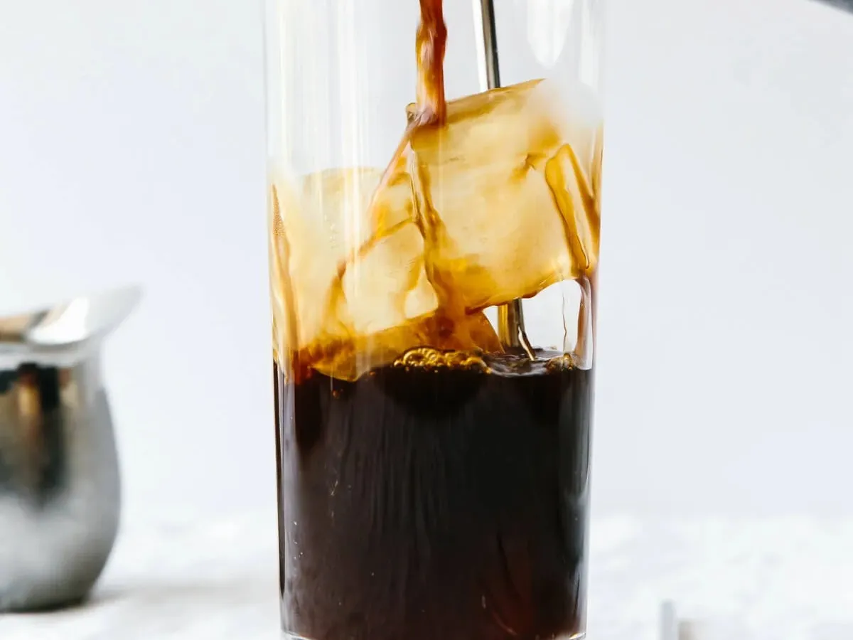 Cold brew coffee poured over ice into a tall glass
