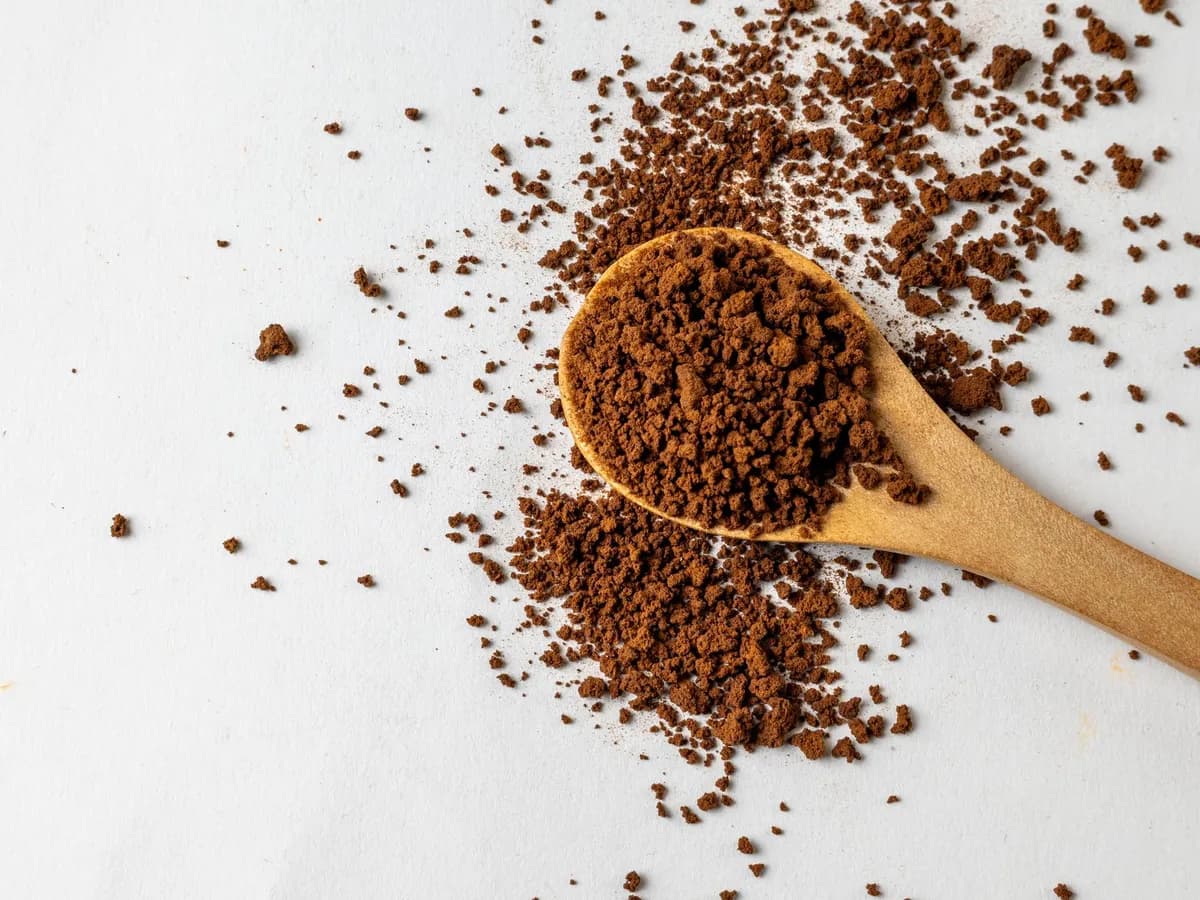 Instant coffee granules on a wooden spoon