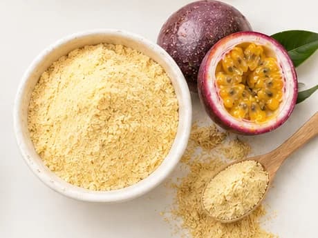 Passion fruit powder in a bowl beside a halved passion fruit